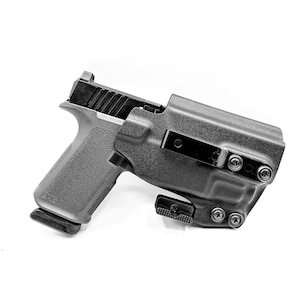 May include: A black handgun with a black holster. The holster has a belt clip and multiple screws.