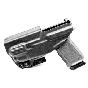 May include: A black polymer holster with a black handgun inside. The holster has a belt clip and a thumb release.