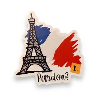 May include: A sticker with a black Eiffel Tower design, a blue, white, and red French flag, and the word "Pardon?". A yellow tile with the letter "L" is also included. The design is a nod to French culture.