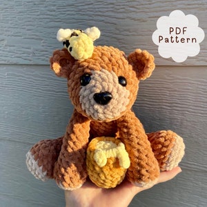 Peut inclure: Patron de crochet pour un ours en peluche brun tenant un pot de miel. L'ours a une abeille jaune et noire sur la t&ecirc;te. Le patron est disponible en t&eacute;l&eacute;chargement PDF.