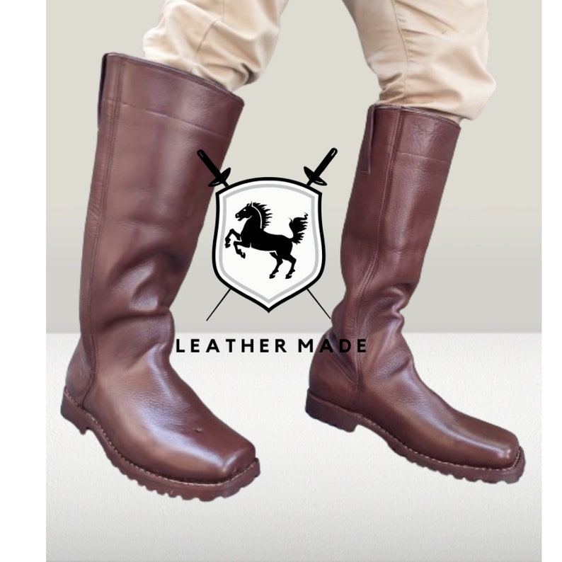 K&ouml;nnte beinhalten: Ein Paar braune, kniehohe Lederstiefel mit quadratischer Spitze und dicker Sohle. Die Stiefel werden von Leather Made hergestellt.