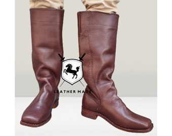 May include: A pair of knee-high brown leather boots with a square toe and a low heel. Between the boots is a white shield-shaped logo featuring a black horse silhouette and two crossed swords, with the text LEATHER MADE printed below the shield.