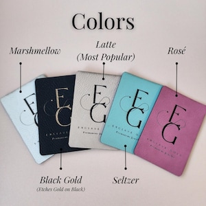 a collection of five different colored leather tags or coasters, each with a unique color and design.