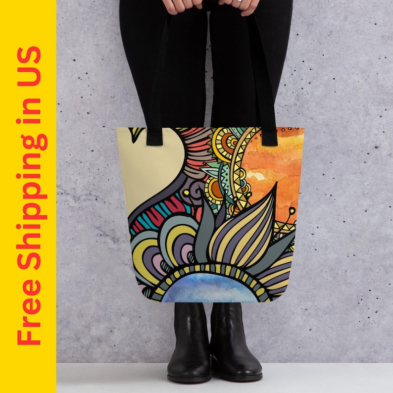 May include: A colorful tote bag with a mandala-like design featuring yellow, orange, blue, green, and purple hues. The bag has black handles.