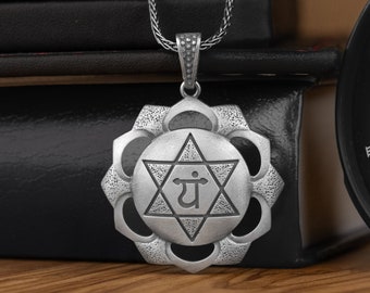 May include: Silver necklace with a pendant featuring a six-pointed star with the Sanskrit symbol "yam" inside, surrounded by a circular design with eight petals.