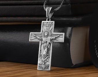 May include: Silver pendant necklace featuring a detailed cross with a depiction of Jesus Christ. The cross is adorned with a dove and floral accents.