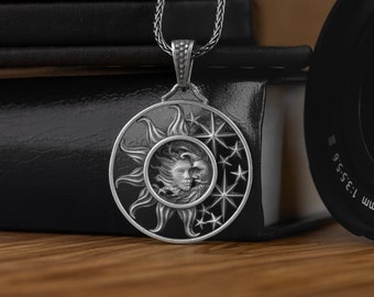 May include: A silver necklace with a pendant featuring a sun and moon design. The pendant is detailed with a face on each celestial body and stars surrounding the moon.