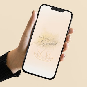 以下が含まれることがあります： 薄い桃色の背景に、金色の蓮の花と「DIVINE Surrender」という文字が書かれた壁紙が表示されているスマートフォン