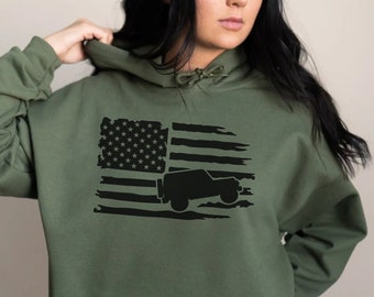 May include: A green hooded sweatshirt with a black distressed American flag design featuring a silhouette of a jeep.