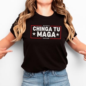 May include: Black t-shirt with the text "CHINGA TU MAGA" in white letters with red stars on a red rectangle.