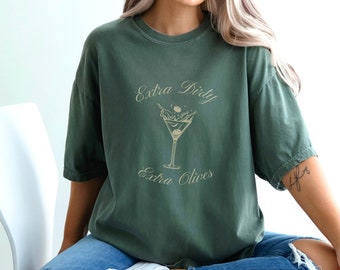 May include: A green t-shirt with the text "Extra Dirty Extra Olives" and a martini glass with olives graphic.