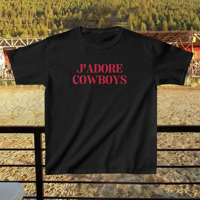 May include: Black t-shirt with the text "J'ADORE COWBOYS" printed in red.