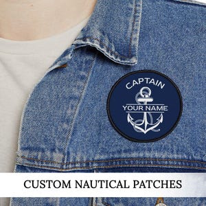 May include: A navy blue, circular patch with a white anchor design and the words "CAPTAIN" and "YOUR NAME". The patch is on a denim jacket. The text "CUSTOM NAUTICAL PATCHES" is at the bottom of the image.
