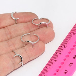 Può includere: Quattro anelli d'argento a forma di mezzaluna su una mano. Gli anelli sono regolabili e possono essere indossati su qualsiasi dito.