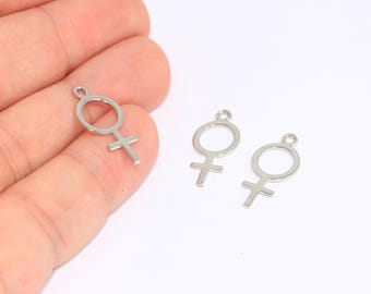 Puede incluir: Tres abalorios de metal plateado en forma de símbolo femenino.