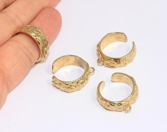 May include: Four gold-tone metal rings with a textured surface. Each ring has a small loop on one side.