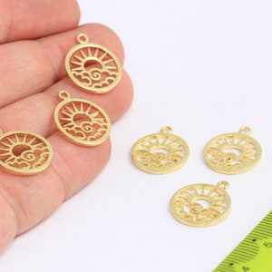 Könnte beinhalten: Fünf goldfarbene Metall-Anhänger mit einem Sonnen- und Wolken-Design. Die Anhänger sind etwa 2,5 cm im Durchmesser und haben ein Loch oben zum Anbringen an einer Halskette oder einem Armband.