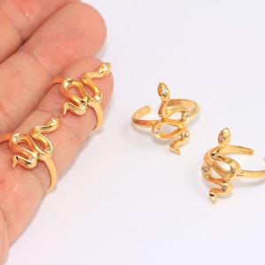 Peut inclure: Trois bagues en or en forme de serpent avec des strass transparents. Les bagues sont réglables et ont un design simple.