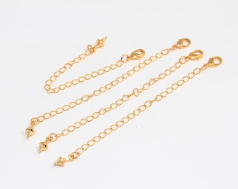 May include: Four gold chain extenders with lobster claw clasps and decorative tips. The extenders are approximately 2 inches long.