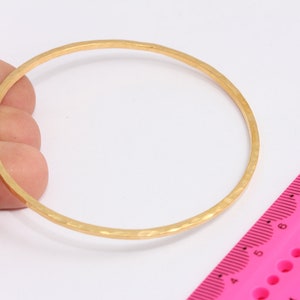 Op de afbeelding: Een gouden armband met een gehammerde afwerking. De armband heeft een diameter van ongeveer 15 cm.