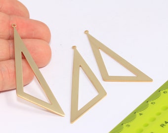 May include: Three gold-colored metal triangle shapes with a hole at the top. The triangles are hollow and have a slightly angled design. A ruler is in the background.