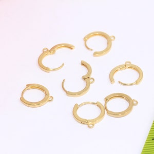 May include: Six gold-toned hoop earring findings with a jump ring attached to each hoop.