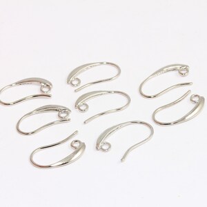 May include: A set of six silver-toned earring hooks. The hooks are made of metal and have a smooth, curved shape. They are designed to be used with a variety of earring styles.