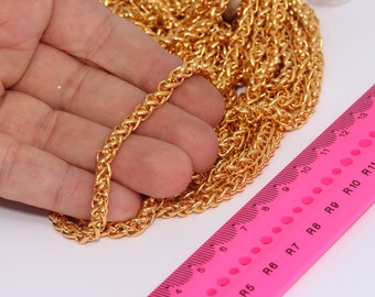 May include: A close-up of a gold chain necklace, with a ruler in the background. The chain is approximately 12 inches long.