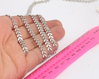 May include: Silver chain with a chevron pattern. The chain is approximately 12 inches long and is shown next to a pink ruler.