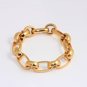 May include: A gold chain bracelet with large, oval-shaped links.