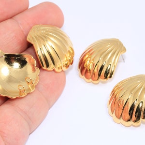 Pode incluir: Quatro brincos dourados em forma de concha. Os brincos são todos do mesmo tamanho e forma, e têm um acabamento liso e brilhante.