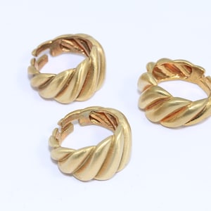May include: Three gold-toned rings with a twisted rope design. The rings are open and adjustable.