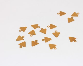 May include: A collection of small, gold-colored triangle charms with a loop at the top for jewelry making. The charms are scattered on a white surface, offering a simple, clean aesthetic. These charms are ideal for DIY jewelry projects.
