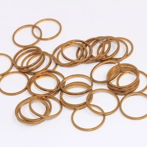 May include: A pile of gold-colored metal rings, likely for jewelry making or craft projects.