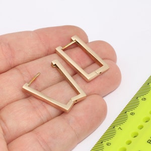 Può includere: Un paio di orecchini a cerchio dorati con forma rettangolare. Gli orecchini sono lunghi circa 2,5 cm.