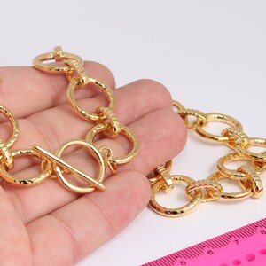 May include: A gold chain necklace with a textured, chunky link design. The necklace has a toggle clasp.