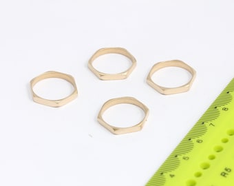 Puede incluir: Cuatro anillos hexagonales de color dorado sobre una superficie blanca. Los anillos son todos del mismo tamaño y forma.