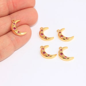 May include: Five gold crescent moon charms with pink rhinestones. The charms are perfect for jewelry making or crafting.
