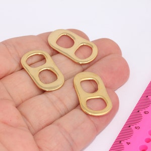 Könnte beinhalten: Drei goldfarbene Metallringe mit einem Doppel-Loop-Design. Die Ringe haben einen Durchmesser von etwa 2,5 cm.