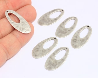 May include: Six silver oval-shaped metal charms with a hole in the center. The charms have a hammered texture.