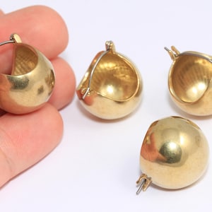 Puede incluir: Cuatro pendientes de aro de oro con un diseño redondo y liso. Los pendientes están hechos de un metal brillante y tienen un estilo simple y clásico.