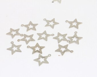 Puede incluir: Una colección de dijes de estrella de metal plateado con un diseño recortado. Los dijes tienen un bucle en la parte superior para sujetarlos a joyas u otras manualidades.