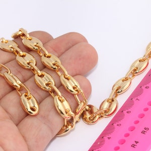 Puede incluir: Un collar de cadena de oro con un diseño de eslabón marinero. La cadena está colocada sobre una mano y una regla rosa, mostrando la longitud de la cadena.