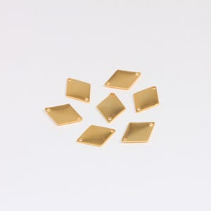 May include: Eight gold diamond-shaped metal charms with two small holes in each charm.