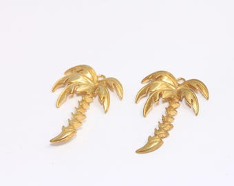 May include: A pair of gold palm tree earrings. The earrings are made of metal and have a detailed design.