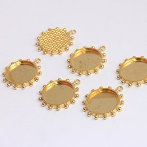 Può includere: Sei vassoi pendenti in metallo dorato con un bordo rotondo smussato e un piccolo anello nella parte superiore. I vassoi hanno un bordo testurizzato e perlato.