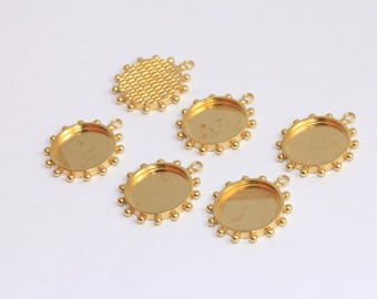 May include: Six gold-toned metal pendant trays with a round, bevelled edge and a small loop at the top. The trays have a textured, beaded border.