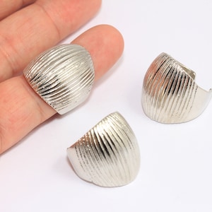 Puede incluir: Tres anillos de plata con una superficie texturizada estriada. Los anillos tienen forma de cúpula.