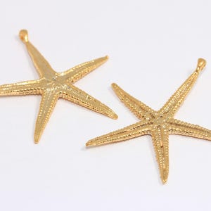 Puede incluir: Dos abalorios de estrella de mar de color dorado con una superficie texturizada. Los abalorios son perfectos para la elaboración de joyas o manualidades.