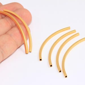 May include: Five gold-colored metal hoops, each with a slightly different curve. The hoops are arranged in a semi-circle, with the largest hoop at the top and the smallest hoop at the bottom.